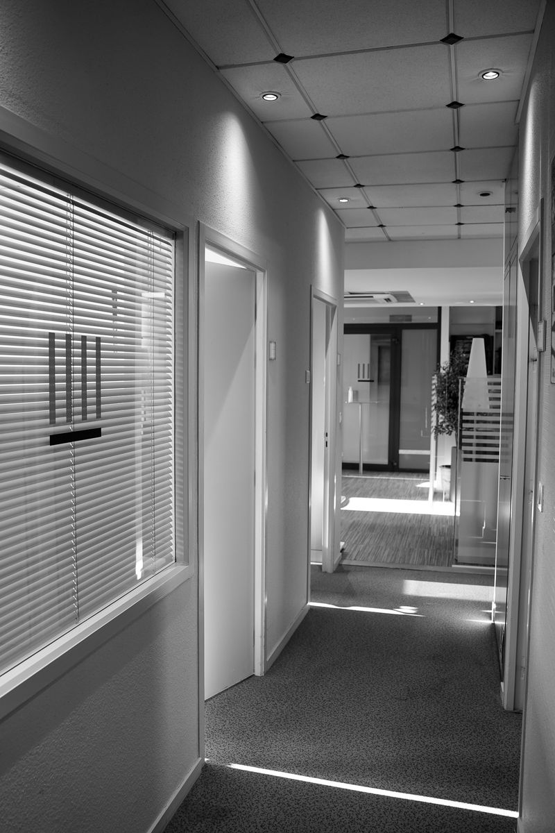 Le couloir du cabinet en noir et blanc, le logo sur la cloison vitrée